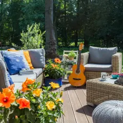 Urocza aranżacja działki rekreacyjnej: wygodna sofa, fotele, stolik z maszyną do pisania i gitara.