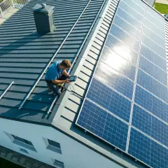 Instalator sprawdza montaż paneli słonecznych na dachu, pokazując, jak zrobić panel słoneczny.