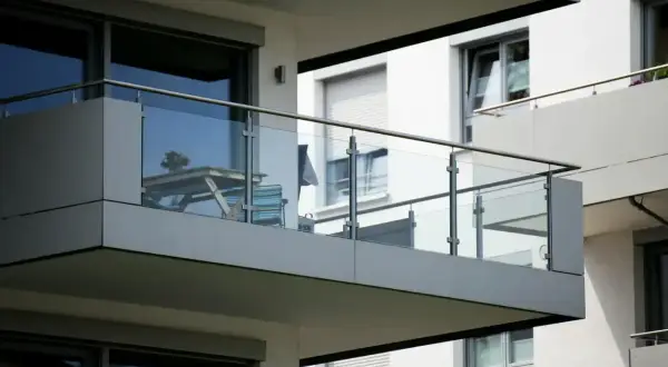 Nowoczesny balkon loggia z przeszkloną balustradą, stolikiem i krzesłem.