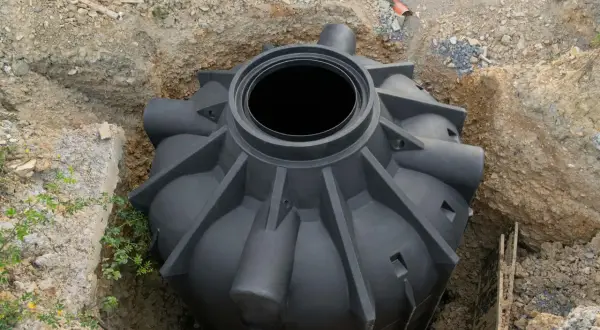 Rozpoczęcie montażu szamba plastikowego. Zbiornik czeka na umieszczenie w wykopie.