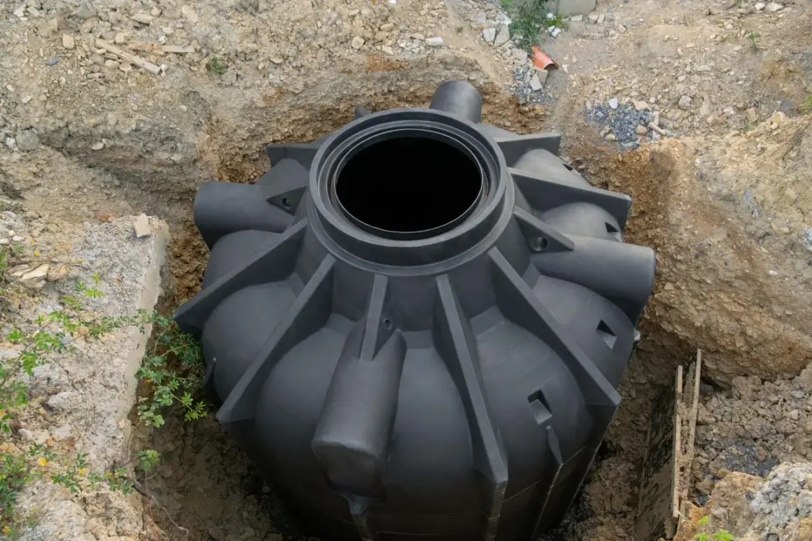 Rozpoczęcie montażu szamba plastikowego. Zbiornik czeka na umieszczenie w wykopie.