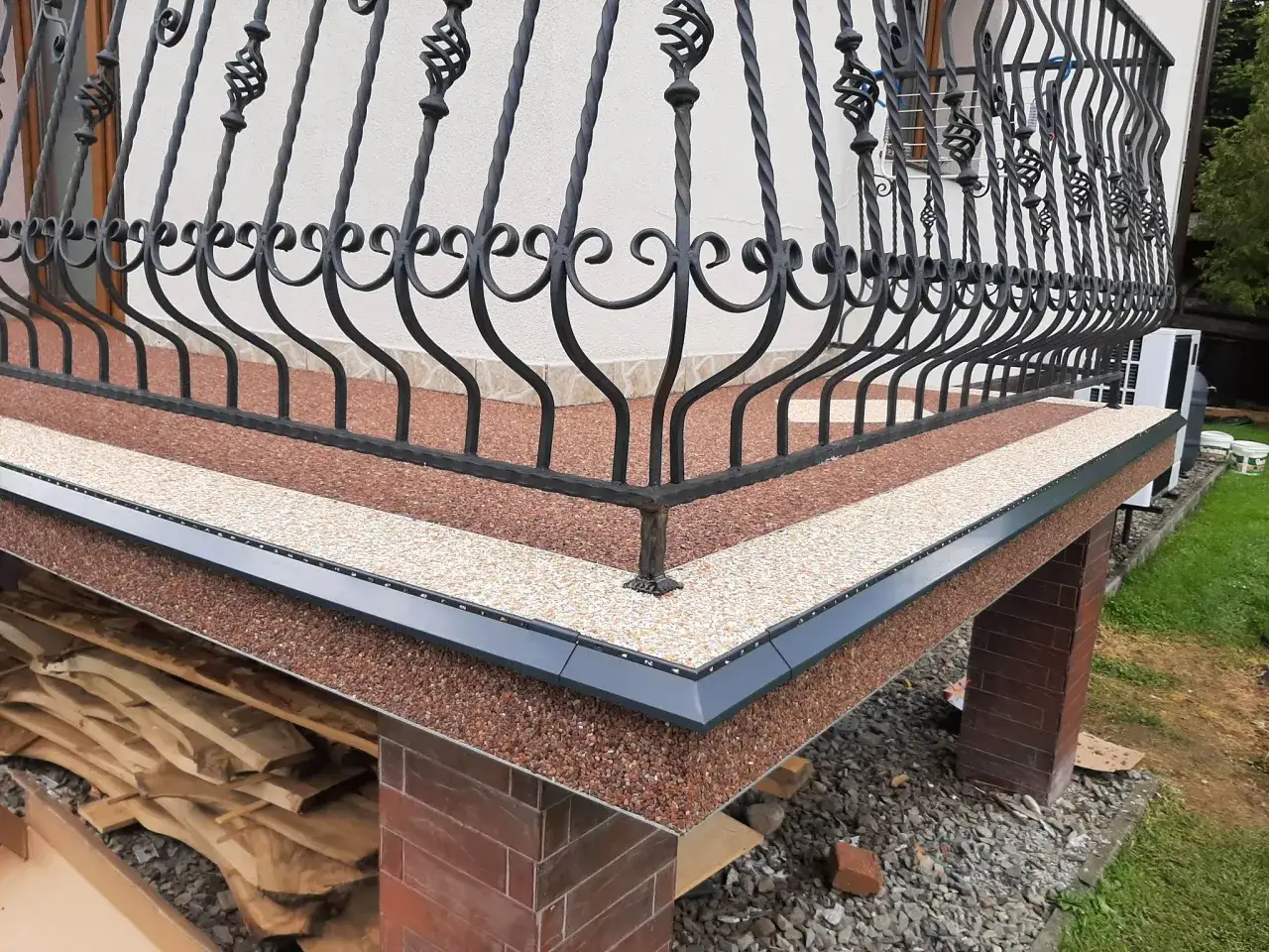 Jak zrobić kamienny dywan na tarasie? Zobacz efektowną posadzkę z kamyczków i ozdobną balustradę.