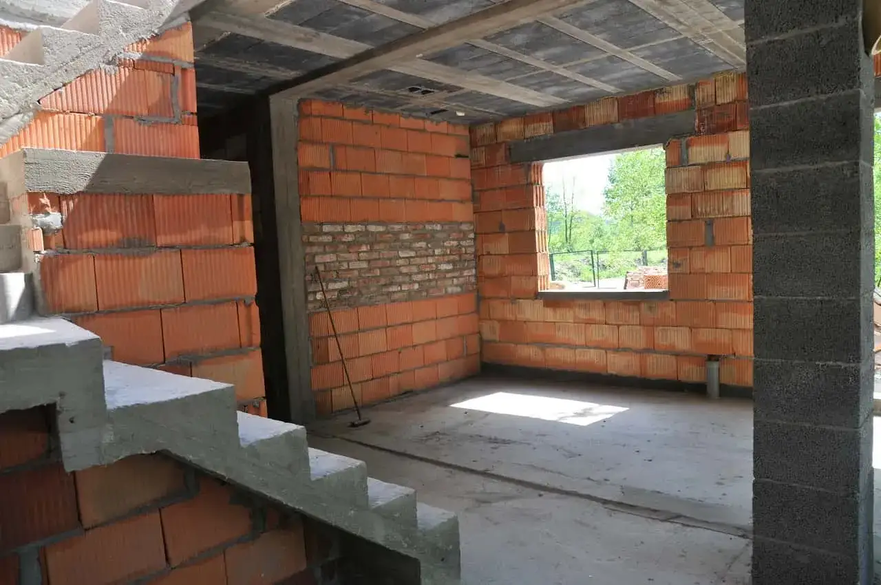Wnętrze w budowie, ściany z pustaków ceramicznych, betonowe schody i strop. Trwa samowolne przekształcenie budynku gospodarczego na mieszkalny.