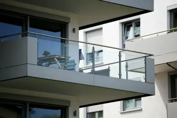 Nowoczesny balkon loggia z przeszkloną balustradą, stolikiem i krzesłem.